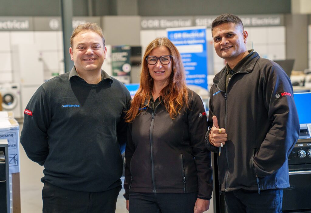 DR electrical team in the showroom similing at camera.